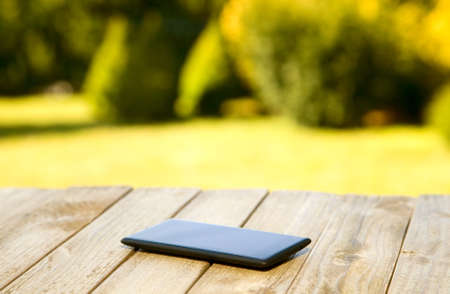 Mobile phone placed on wooden floor with nature background