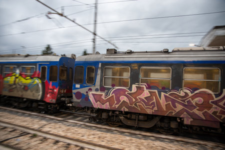 teni,italy may 28 2020 :trains panning at the station at speed with people inside and colored by...
