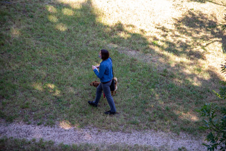 terni,italy june 01 2020 :woman strolling with her dog at park in the morningのeditorial素材