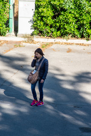terni,italy june 01 2020 :girl at park strolling with smatphone in the morningのeditorial素材