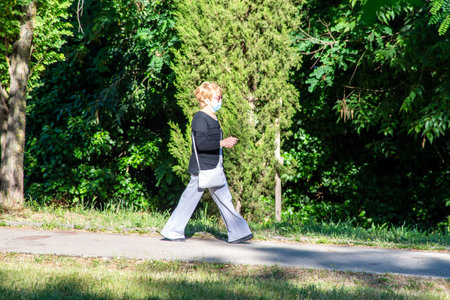 terni,italy june 01 2020 :woman strolling wearing mask at parkのeditorial素材