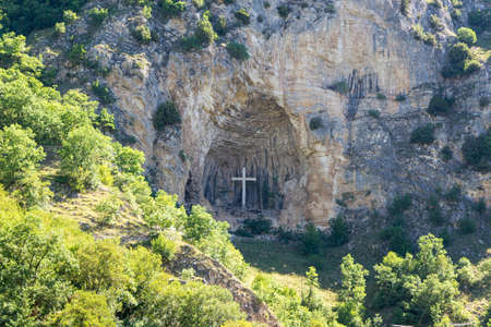 cross placed in a niche on a mountainの写真素材