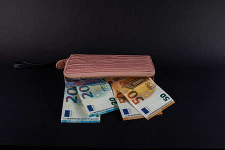 womens wallet on top of euro banknotes