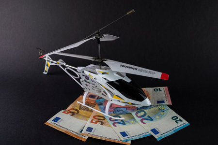 model helicopter on top of euro banknotes of different denominationsのeditorial素材