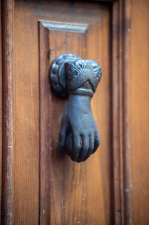 knocker in the shape of a knocking hand in black metalの写真素材