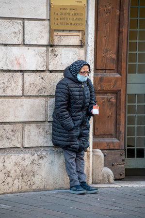 terni, italy actober 10 2020: a man in the park with his dog doing needs with a medical maskのeditorial素材