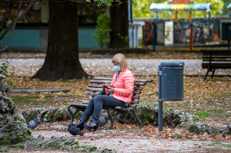 terni, italy october 13 2020: black man sitting on a bench at the parkのeditorial素材