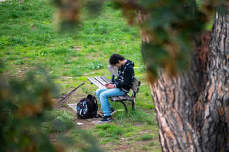 terni, italy october 13 2020: black man sitting on a bench at the parkのeditorial素材
