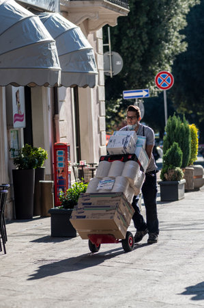 terni, italy october 21 2020: courier carrying packages in a shopのeditorial素材
