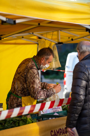 walking man with medical mask at the market selling vegetablesのeditorial素材