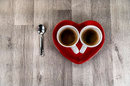 two teaspoons of coffee with a heart-shaped saucer and a teaspoonの写真素材