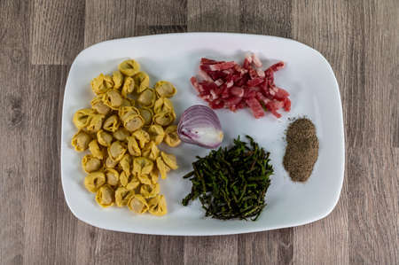 ingredients for cappelletti pancetta and asparagus creamed in a pan with parmesanの写真素材