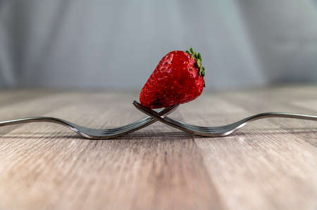 composition with strawberry and forks viewed in various perspectives on wooden tableの写真素材