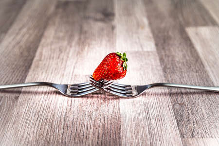 composition with strawberry and forks viewed in various perspectives on wooden tableの写真素材