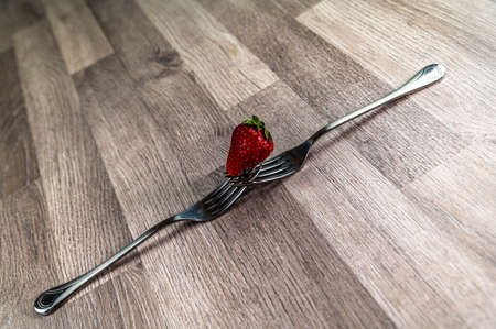 composition with strawberry and forks viewed in various perspectives on wooden tableの写真素材