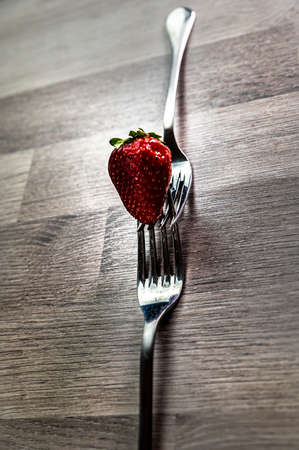 composition with strawberry and forks viewed in various perspectives on wooden tableの写真素材