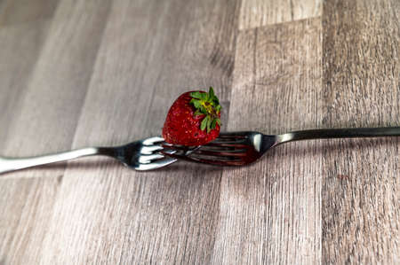 composition with strawberry and forks viewed in various perspectives on wooden tableの写真素材