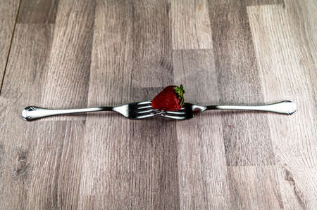 composition with strawberry and forks viewed in various perspectives on wooden tableの写真素材