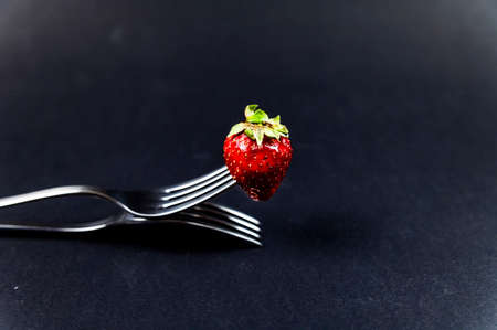 composition with strawberry and forks viewed in various perspectives on wooden tableの写真素材