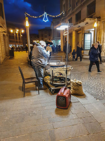 terni,italy december 05 2020:man selling cooked chestnuts to the public in the city centerのeditorial素材