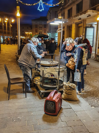 terni,italy december 05 2020:man selling cooked chestnuts to the public in the city centerのeditorial素材