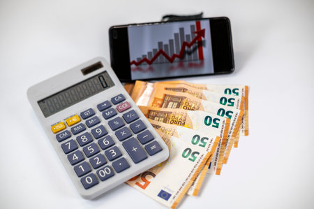 50 euro bills with calculator and graph on white backgroundの写真素材
