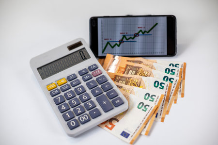 50 euro bills with calculator and graph on white backgroundの写真素材