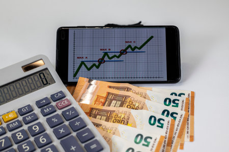 50 euro bills with calculator and graph on white backgroundの写真素材