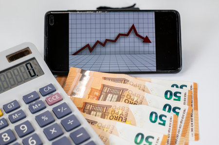 50 euro bills with calculator and graph on white backgroundの写真素材