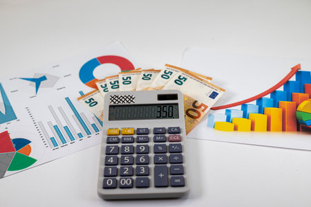 50 euro banknotes with statistics and calculator on white backgroundの写真素材