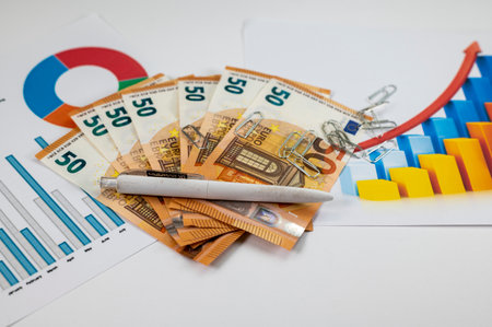 50 euro banknotes with statistics and calculator on white backgroundの写真素材