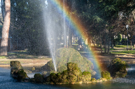 fountain with rainbow at the park in the center of terniの写真素材