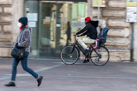 terni, italy february 19 2021: man panning girl on bicycle downtownのeditorial素材