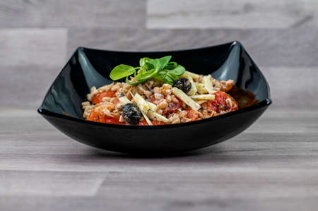 served on black plate of farroset salad on wooden tableの写真素材