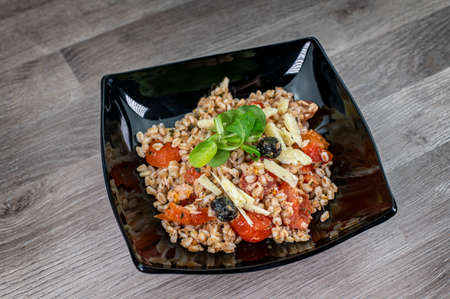 served on black plate of farroset salad on wooden tableの写真素材