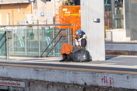 terni, italy february 24 2021: clochard black woman with black bags sitting at the stationのeditorial素材