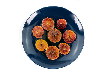 oranges seasoned with oil salt and pepper on a blue plate and wooden background orangesの写真素材