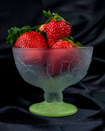 cup of ripe strawberries on wooden backgroundの写真素材