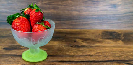 cup of ripe strawberries on wooden backgroundの写真素材