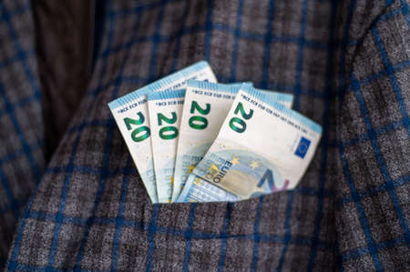 pocket of the plaid jacket coming out of 20 euro billsの写真素材