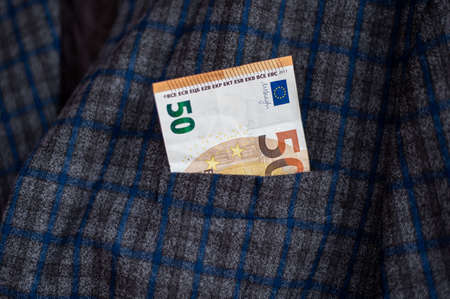 pocket of the plaid jacket coming out of 20 euro billsの写真素材