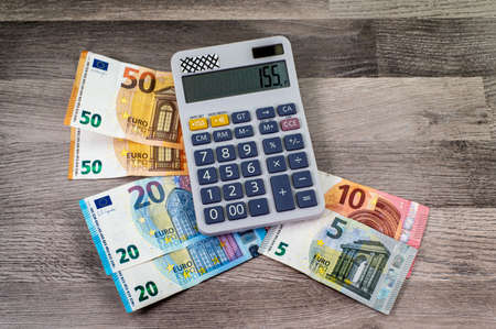 euro money of different denominations and calculators on wooden backgroundの写真素材