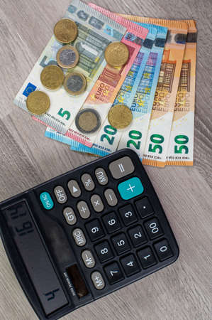 euro money of different denominations and calculators on wooden backgroundの写真素材