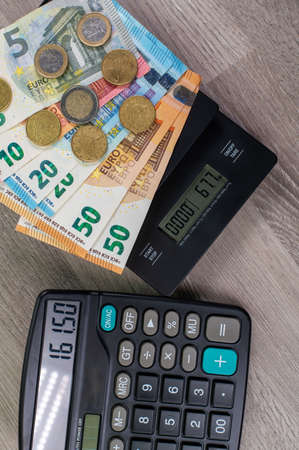 euro money of different denominations and calculators on wooden backgroundの写真素材
