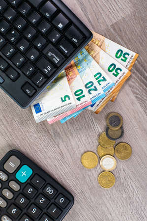 euro money of different denominations and calculators on wooden backgroundの写真素材