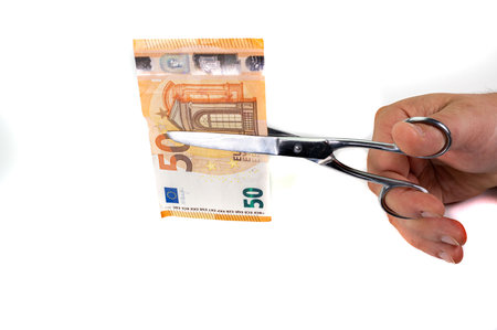 cut 50 euro banknotes with scissors on white backgroundの写真素材