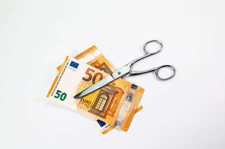 cut 50 euro banknotes with scissors on white backgroundの写真素材