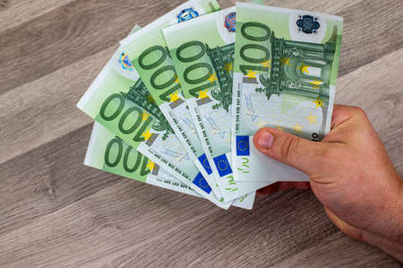 100 euro banknotes and tepetino with euro symbol on wooden tableの写真素材