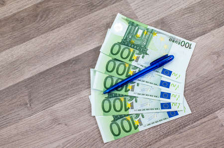 100 euro banknotes and tepetino with euro symbol on wooden tableの写真素材