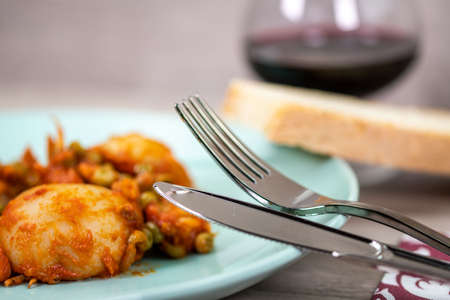 composition of plate with cuttlefish and peas on wooden table with glass cutleryの写真素材